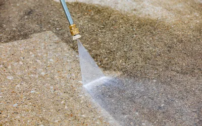 Technician performing high-pressure washing on a residential driveway in Cairns