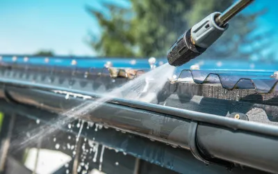 Technician using pressure washing equipment to clean a roof in Cairns