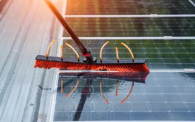 Technician cleaning solar panels with pressure washing equipment in Cairns